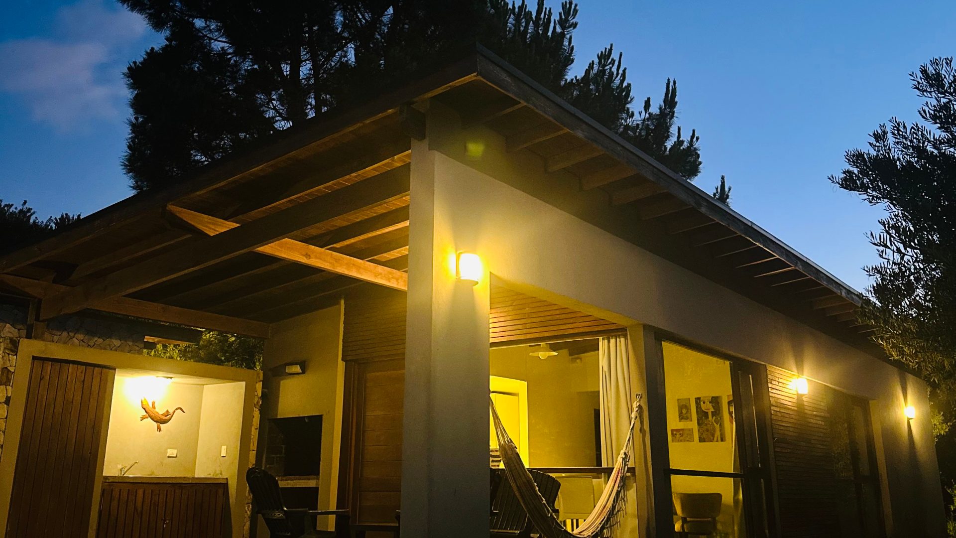 La galería de una de las casas, iluminada, al caer la tarde