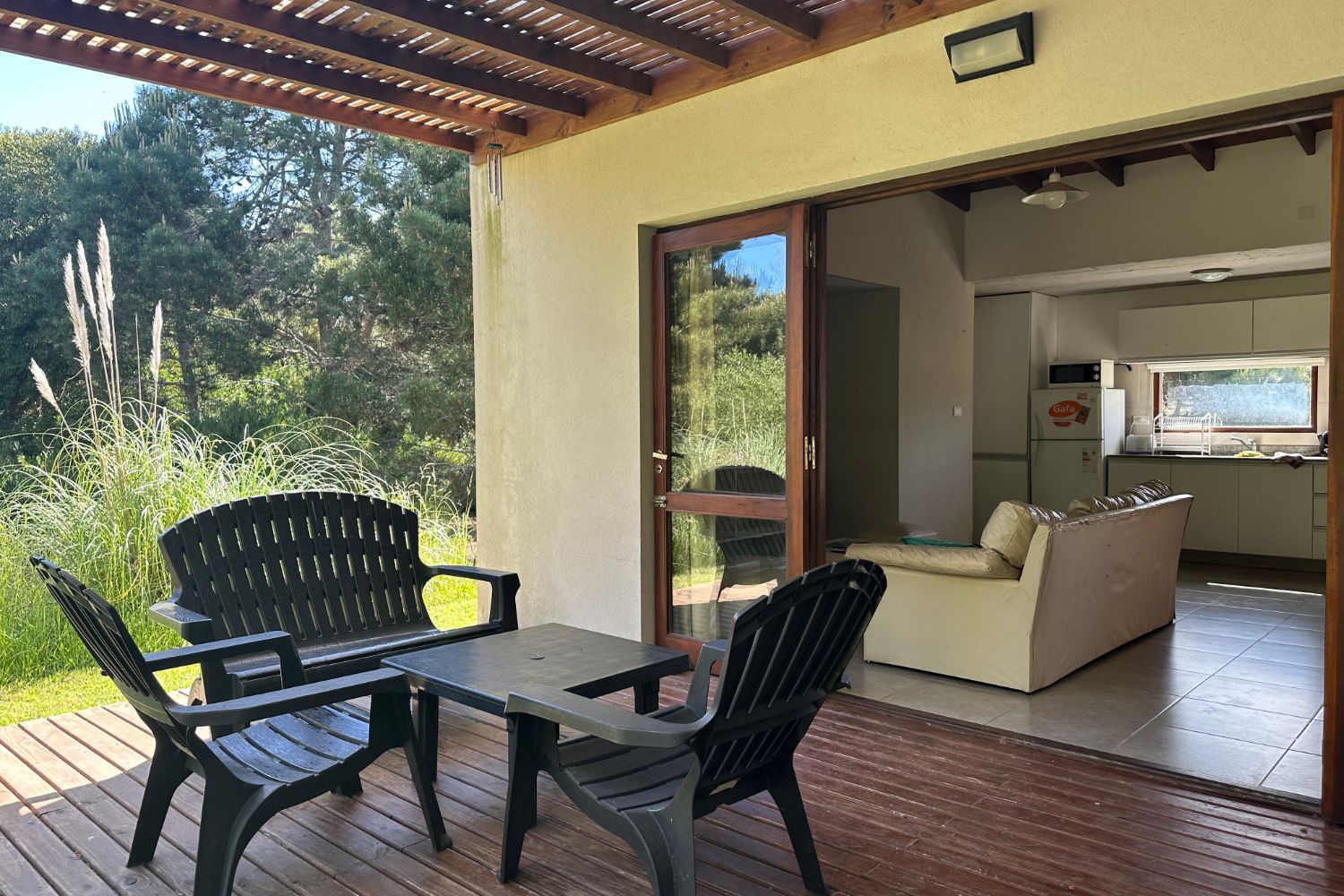 La galería cubierta con pérgola, abierta al estar